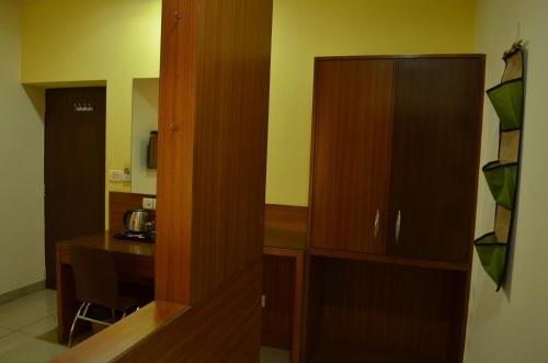 a kitchen with a wooden cabinet and a desk at Athasri Hotel Cubbon Road in Bengaluru