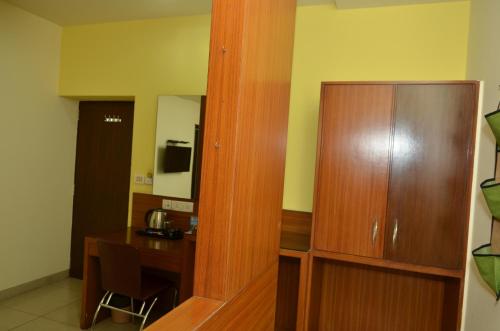 a room with a desk and a wooden cabinet at Athasri Hotel Cubbon Road in Bengaluru