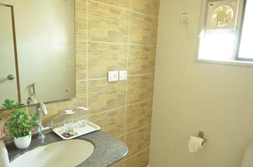 a bathroom with a sink and a mirror at Athasri Hotel Cubbon Road in Bengaluru