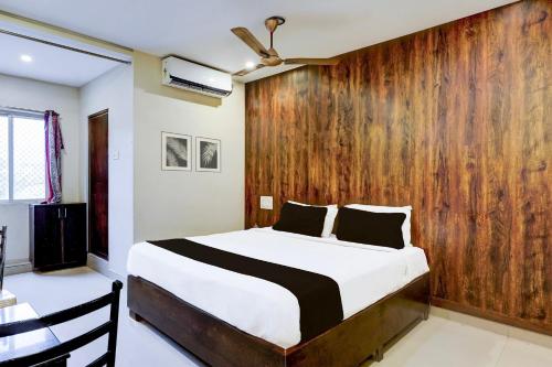 a bedroom with a bed and a wooden wall at Super Hotel O Renigunta Near Railway Station in Tirupati