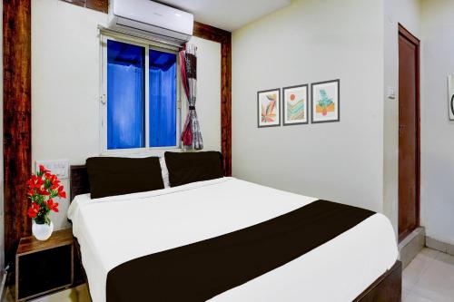 a bedroom with a white bed and a window at Super Hotel O Renigunta Near Railway Station in Tirupati
