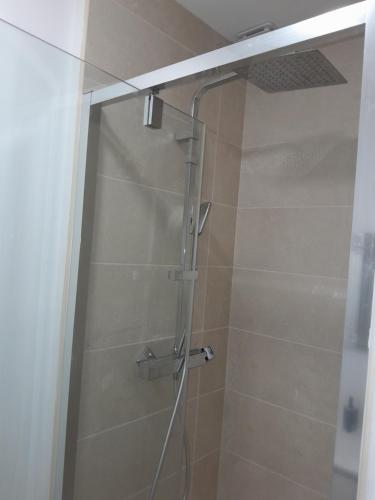 una ducha con puerta de cristal en un baño en Appart neuf, en Le Mans