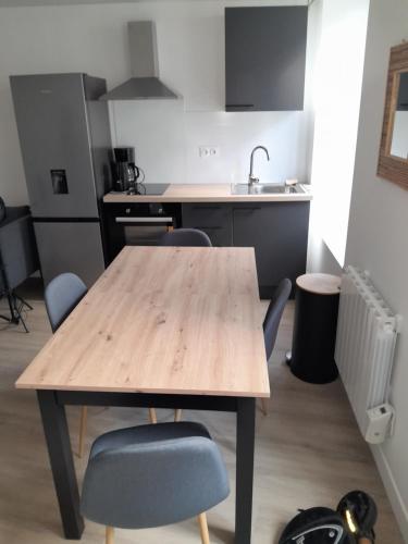 Una cocina con una mesa y sillas de madera. en Appart neuf, en Le Mans