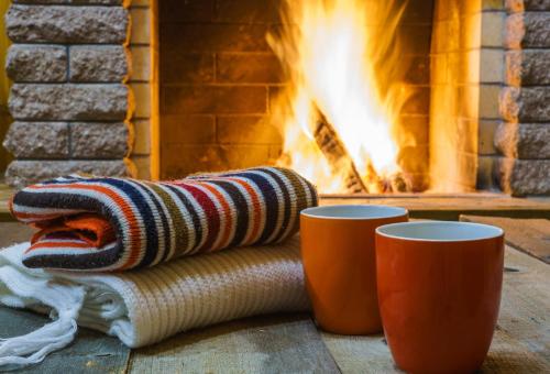 a blanket and two cups in front of a fireplace at Suite Paradiso Umbria 15 minutes A1 Rome 1 hour in Amelia