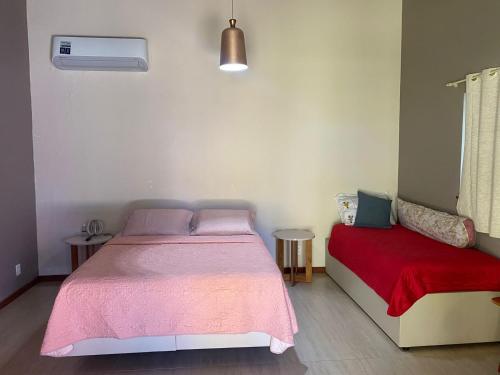 a bedroom with a bed and a red blanket at Pousada Destino in Porto de Sauipe