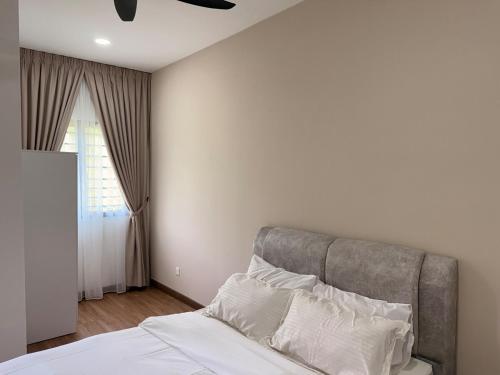 ein Schlafzimmer mit einem Bett mit weißen Laken und einem Deckenventilator in der Unterkunft Kajang KL 10Pax Landed Home Karaoke Netflix Long Stay in Semenyih