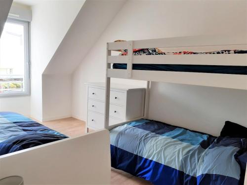 ein Schlafzimmer mit zwei Etagenbetten und einem Bett in der Unterkunft Maison familiale, proche des plages et des commerces in Piriac-sur-Mer