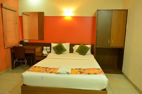 a bedroom with two beds and a desk with a desk at Athasri Hotel Cubbon Road in Bengaluru