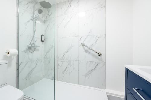 a bathroom with a shower with white marble tiles at Hotel Prince Regent in Weymouth