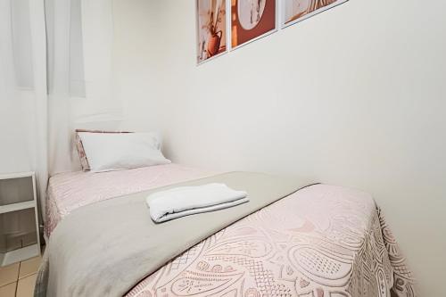 a bed with two white towels on top of it at Ótimo apartamento, ar cond e vaga in Ourinhos