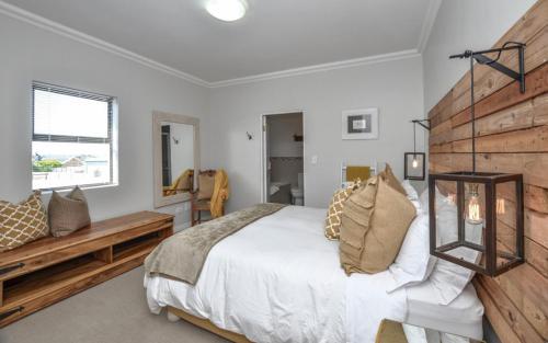 a bedroom with a large bed and a wooden headboard at Apartment 6 in Yzerfontein