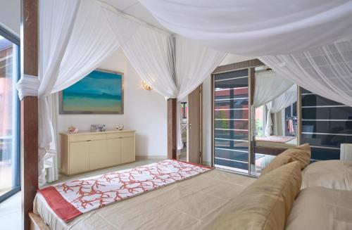 a bedroom with a large bed and a window at Villa Coco Chic - Piscine privée - Paradis Tropical in Pointe aux Piments