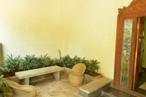 a room with a table and a bench and plants at Athasri Hotel Cubbon Road in Bengaluru