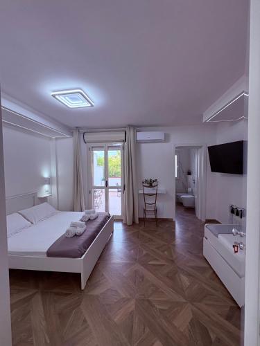 a white bedroom with a bed and a bathroom at Maison24 in Martinsicuro