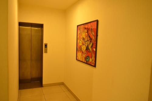a painting hanging on a wall in a hallway at Athasri Hotel Cubbon Road in Bengaluru