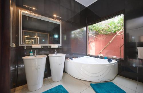a bathroom with a tub and a sink and a window at Villa Coco Chic - Piscine privée - Paradis Tropical in Pointe aux Piments
