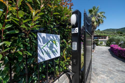 un cartel en una valla con una casa en ella en Villaré, oasi di relax nel verde della Riviera con piscina privata, en Lavagna