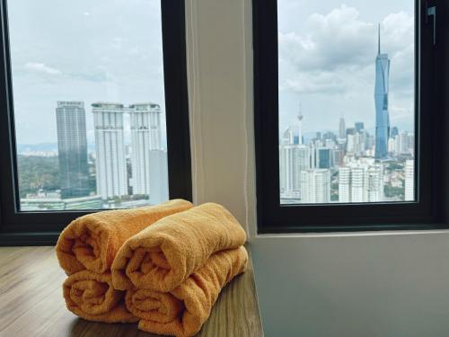 a pile of towels sitting on the floor in front of a window at KL Sentral Monorail 4 pax Kuala Lumpur, Sky Pool Family Merdeka 118 Nice View in Kuala Lumpur