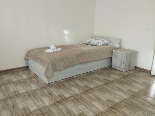 Un dormitorio con una cama y suelo de madera. en Guest House, en Gyumri