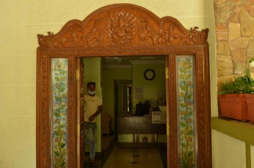 a man is standing in front of a mirror at Athasri Hotel Cubbon Road in Bengaluru