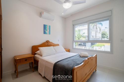 a bedroom with a bed and a window at Apt w/ balcony and grill 220m from the Sea ALB0201 in Florianópolis
