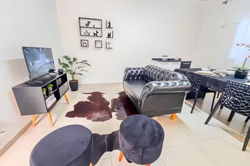 a living room with a leather couch and a table at Vila São José 1 in Ourinhos