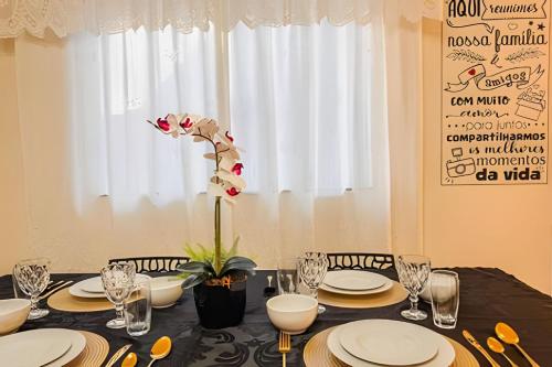 a dining room table with plates and silverware on it at Vila São José 1 in Ourinhos