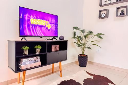 a television on a stand in a living room at Vila São José 1 in Ourinhos