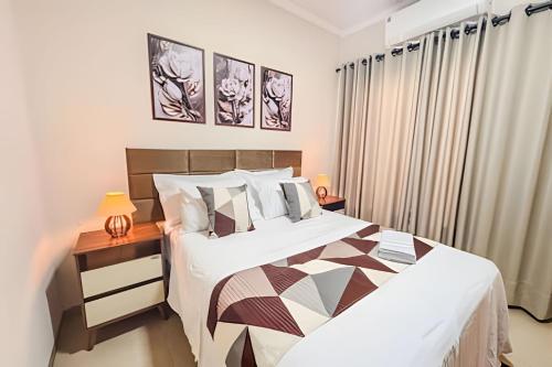 a bedroom with a bed and a table with a lamp at Vila São José 1 in Ourinhos