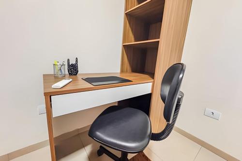 a desk with a chair next to a book shelf at Vila São José 1 in Ourinhos