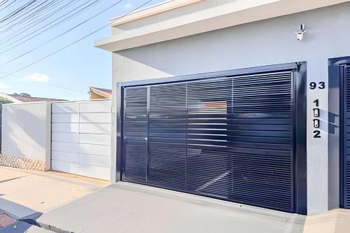 a garage door with black blinds on a house at Vila São José 1 in Ourinhos