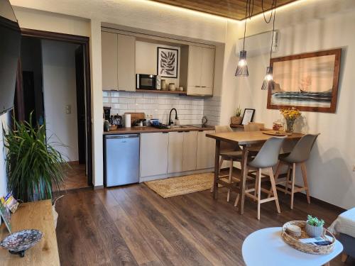 a kitchen and living room with a table and chairs at Halasma Meteora in Kastrákion
