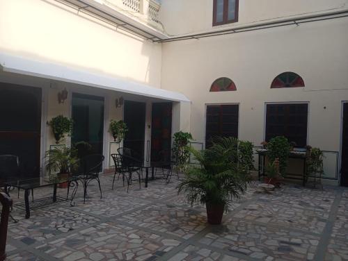 a courtyard with chairs and tables and potted plants at Hotel Heritage Suite Hari Mahal in Jaipur