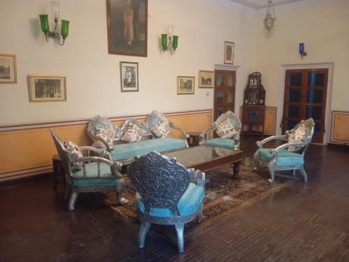 a living room with chairs and a couch and a table at Hotel Heritage Suite Hari Mahal in Jaipur