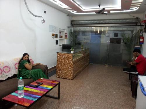 una mujer sentada en un sofá en una habitación en The banaras residency, en Varanasi