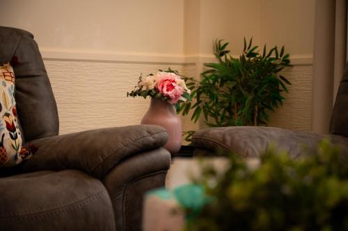 a vase filled with flowers sitting next to a chair at جناح بانورامي in Jeddah