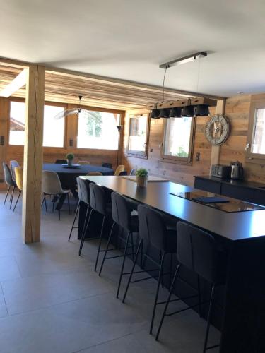 a kitchen with tables and chairs in a room at Chalet Au Chalet de Mel très récent in La Bresse