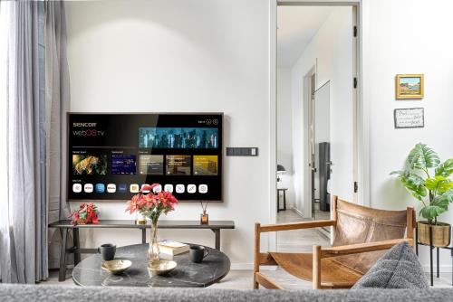 a living room with a table and a tv at Unbeatable Central Location - Reykjavíks Most Exclusive Luxury Apartments in Reykjavík