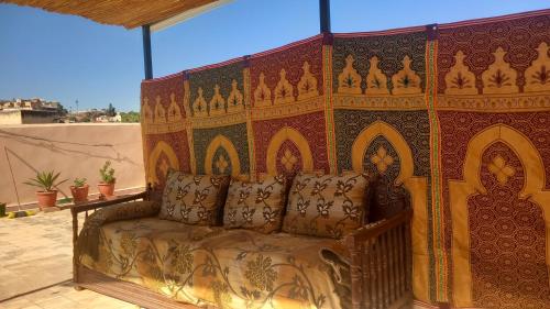 un divano seduto di fronte a una parete colorata di dar ben issa a Fes