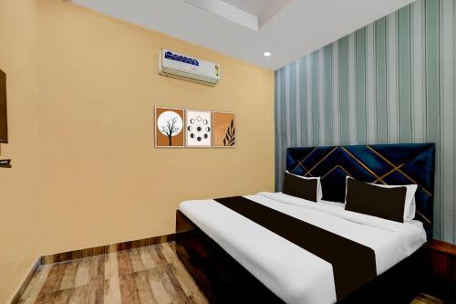 Un dormitorio con una cama con cabecero azul. en Hotel O Lotus Inn, en Faridabad