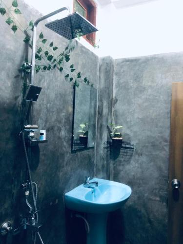 a bathroom with a blue sink and a shower at Ella Green Breeze in Ella