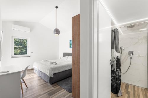 a bedroom with a bed and a bathroom with a shower at Villa Nina with private pool and BBQ near Poreč in Bonaci