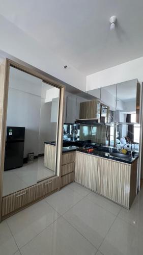 a large kitchen with a counter and a large window at Luxury Apartemen Anderson Benson PTC By Staycation in Surabaya