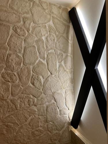 a room with a stone wall with a cross on it at LoveRoom, La suite de l’extase in Puget-sur Argens