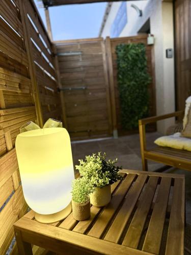 a chair sitting on a wooden table with two potted plants at LoveRoom, La suite de l’extase in Puget-sur Argens