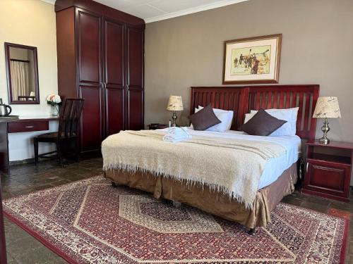 a bedroom with a large bed and a desk at Platrand Lodge 
