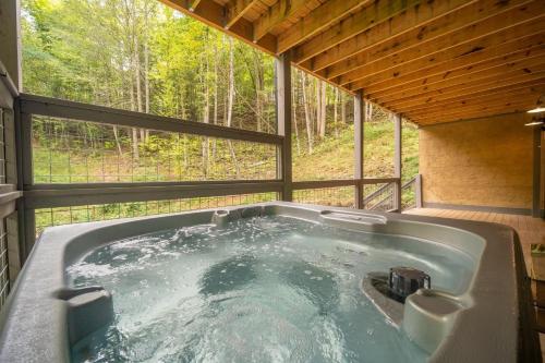 a bath tub in a room with a window at Multi Level Getaway Pool Hot Tub and Fireplace in Pittman Center