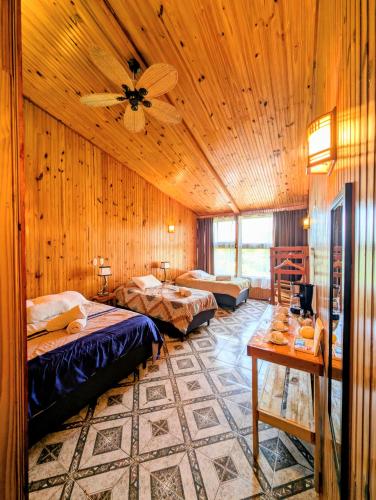 a room with three beds and a ceiling fan at Miztli Lodge & Adventure in Monteverde Costa Rica