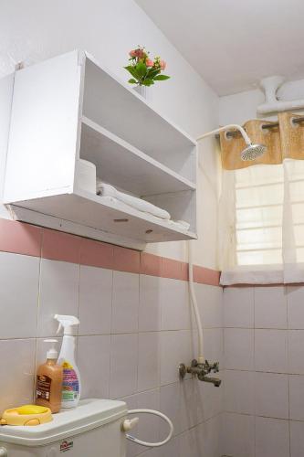 a bathroom with a toilet with a cabinet above it at Yemane luxury Studio in Mombasa