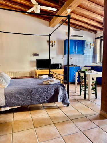 ein Schlafzimmer mit einem Bett und eine Küche mit blauen Schränken in der Unterkunft Cornaro House in Arsos